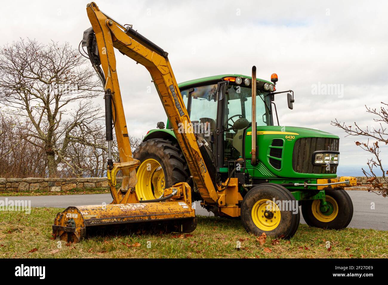 Shenandoah, VA, USA 10/31/2020: Ein grüner John Deere Modell 6430 Traktor mit SEITLICHER hydraulischer Armbefestigung (Bengal XR) von Tiger Mähers. Dieser Anhang Stockfoto