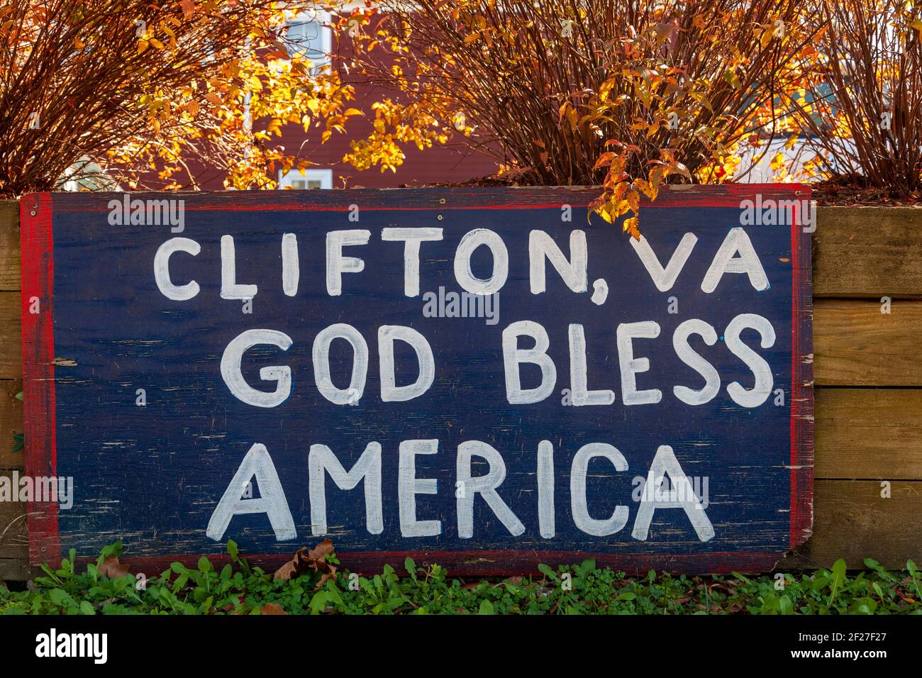 Ein blau bemaltes Holzbrett, das an Holzplanken in der Nähe der Bahngleise befestigt ist, hat eine Notiz darauf, die Clifton, VA God Bless America, sagt. Clifton ist ein s Stockfoto