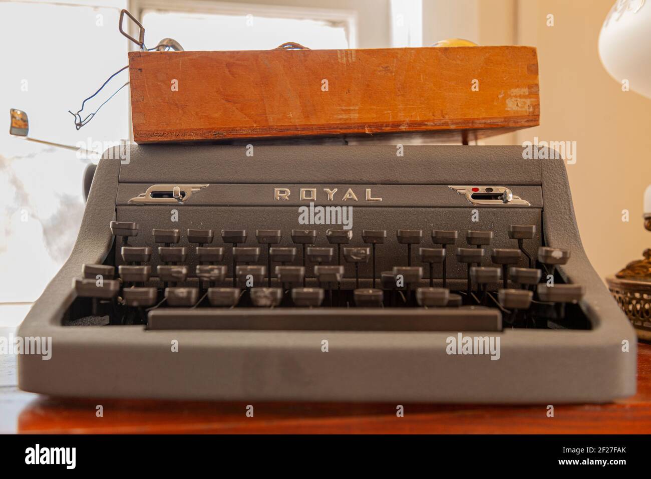 Clifton, VA, USA 11-14-2020: Nahaufnahme einer antiken Schreibmaschine der Marke Royal mit einer braunen Holzkiste. Die Vintage Maschine ist grau mit schwarz Stockfoto