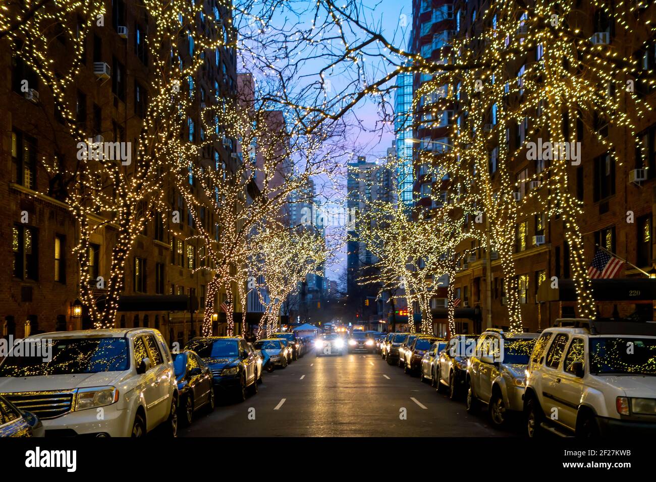 New York Street Night mit Weihnachtsbeleuchtung an Bäumen Mit seitlichem Parkplatz und Verkehr Stockfoto