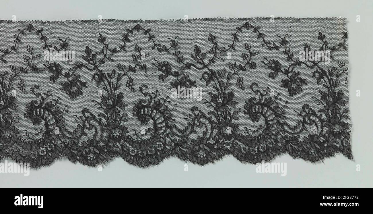 Strook maschinale kant met rozentakken tussen c-vollen langen de onderzijde.Maschine Spitzenstreifen: Maschine chantilly Seite. Das sich wiederholende Muster entlang der Unterseite des Streifens besteht aus C-Voluten, zwischen denen rosa Zweige springen. Die Äste schneiden teilweise einen dünnen Laubgarrier, der sich mit Schleifen und Schleifen an der Spitze des Streifens entlang bewegt. Die Motive sind mit Konturdrähten ausgestattet und werden durch Bearbeitung miteinander verbunden. In den Motiven sind Ziergründe angebracht. Die schräge Kante entlang der Unterseite des Streifens stammt aus dem Muster mit den C-Spannungen und ist mit Picots beendet. Stockfoto
