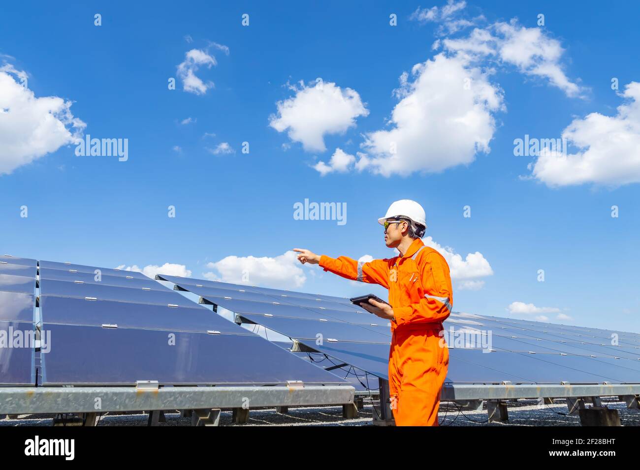 Der Solarpark (Solarpanel) mit Ingenieuren gehen, um den Betrieb des Systems zu überprüfen, Alternative Energie, um die Energie der Welt zu sparen, Photovoltaik Stockfoto