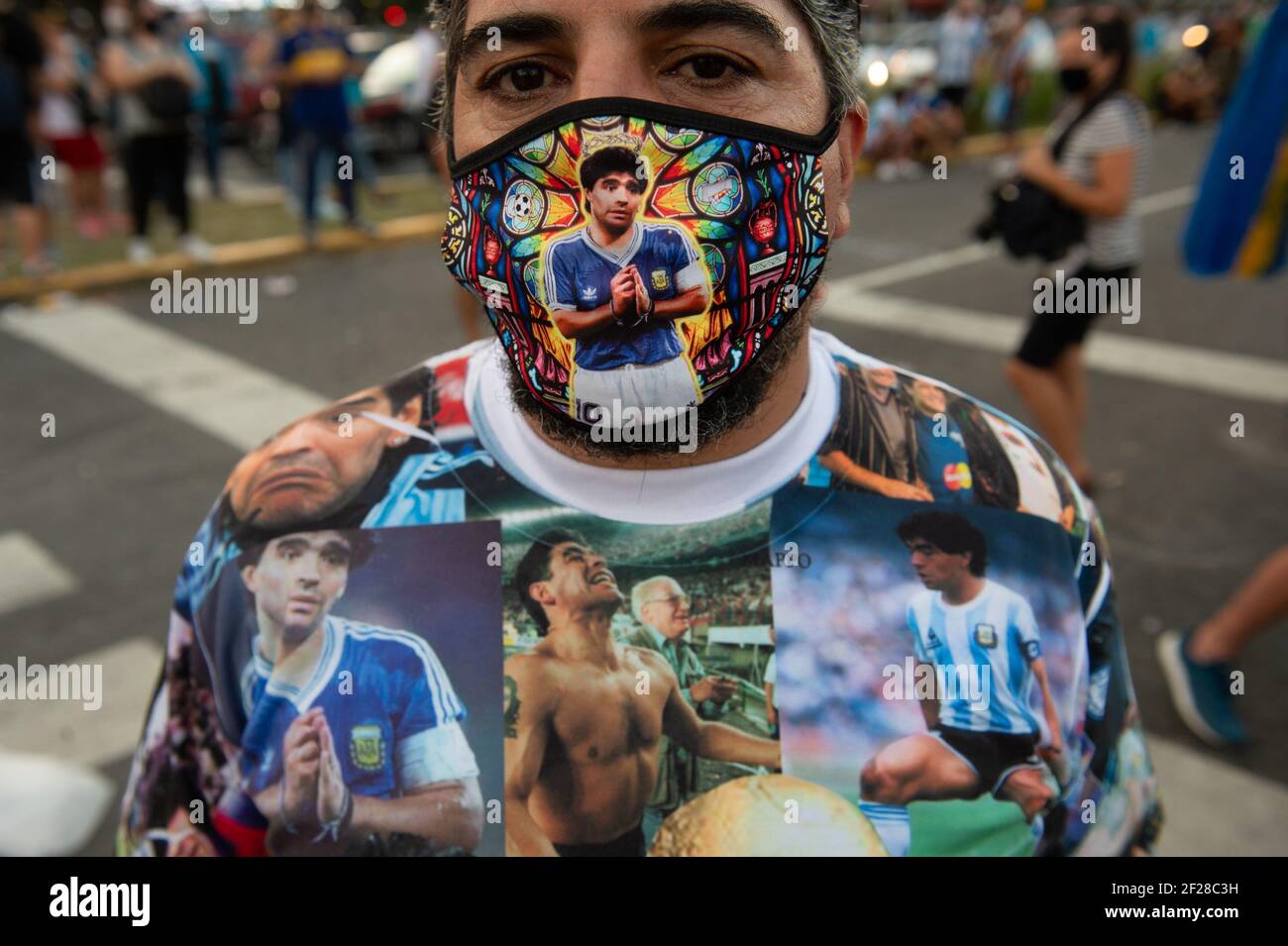 Ein Protestant in einem T-Shirt aus Argentinien und einem Kinnriemen mit einem Porträt von Diego Maradona während der Demonstration.Demonstration in der Innenstadt von Buenos Aires Diego Maradonas Fans und Familienmitglieder behaupteten, der legendäre argentinische Fußballspieler sei getötet worden. "Er starb nicht. Sie töteten ihn", skandierten die Demonstranten. Stockfoto