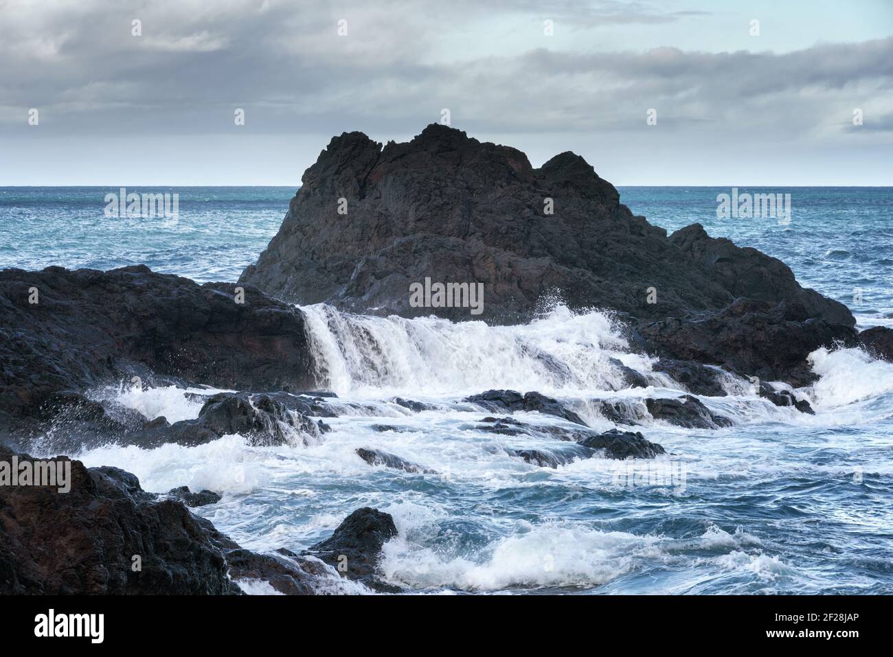 Meereslandschaft mit Wellen, die auf den Felsen in Seixal, Madeira Stockfoto