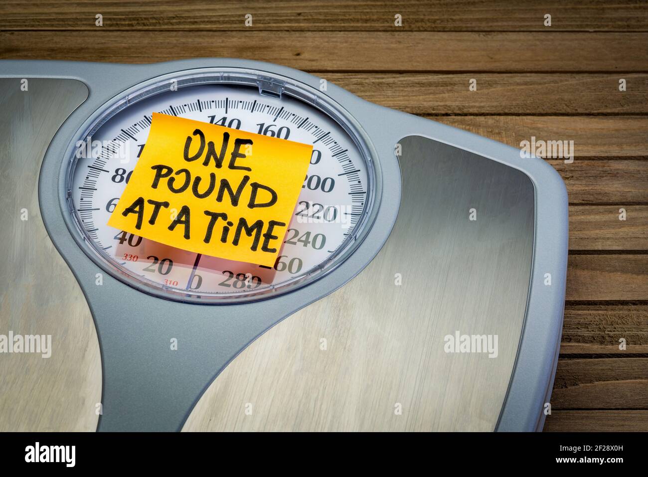 Ein Pfund zu einer Zeit - Motivations-Erinnerung auf einem Bad Waage Gewichtsverlust Konzept Stockfoto