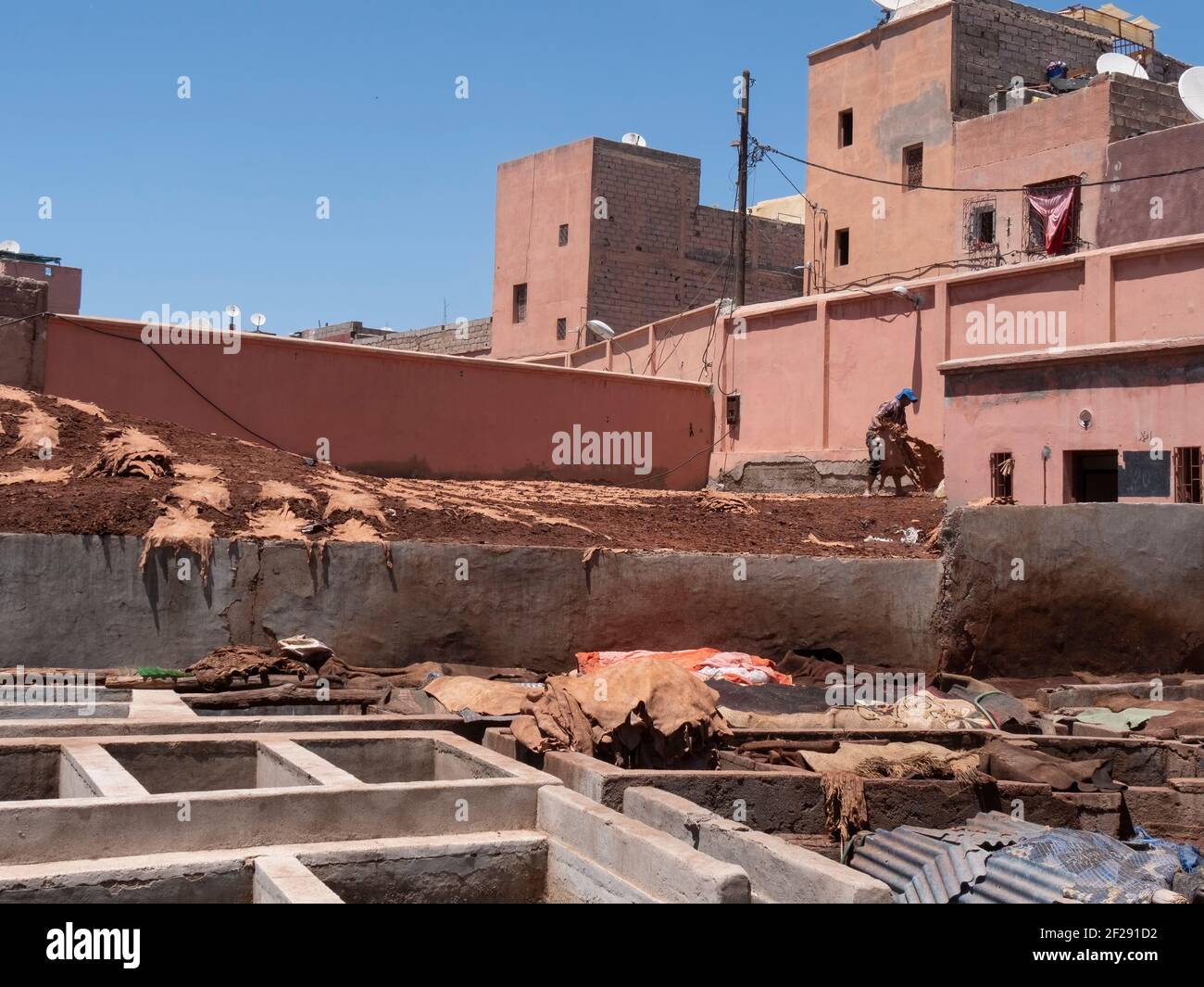 MARRAKESCH, MAROKKO- 10. JUNI 2019: Ein Arbeiter sammelt Leder, das in der Sonne trocknet, in einer der alten Gerbereien in marrakesch Stockfoto