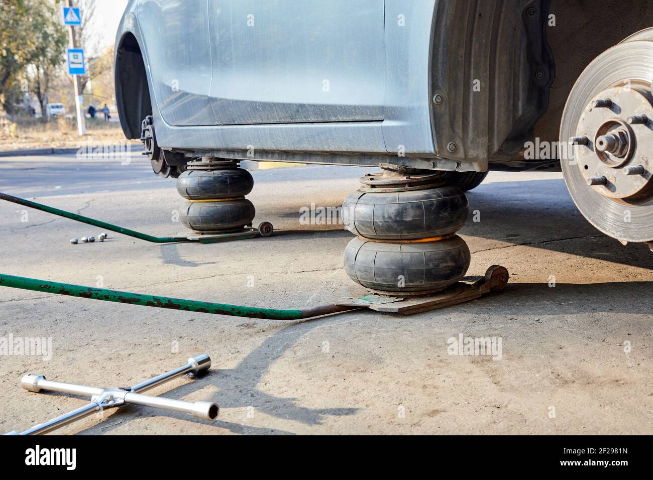 Fahrzeug ohne Räder beim Radwechsel mit Wagenheber angehoben. Saisonaler  Reifenwechsel Stockfotografie - Alamy