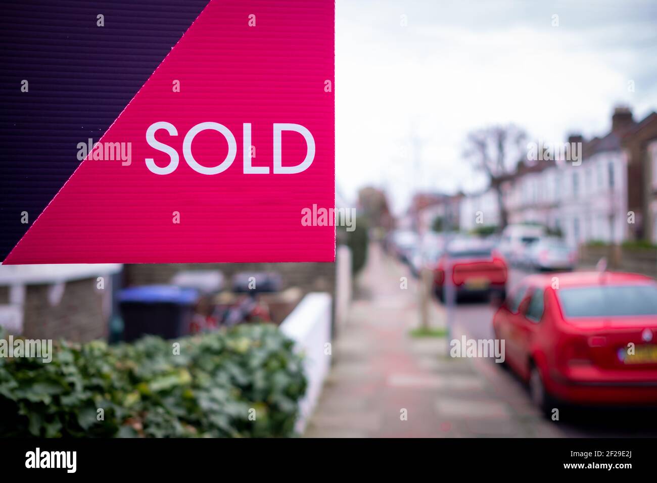 Immobilienmakler VERKAUFT Zeichen auf der Straße der Häuser Stockfoto