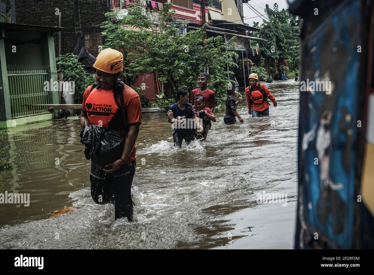 Makassar, Süd-Sulawesi, Indonesien. März 2021, 11th. Rettungskräfte und Bewohner überqueren die Hochwasserstelle. Überschwemmungen ereigneten sich in der Stadt Makassar und führten dazu, dass Dutzende von Häusern in Wasser getaucht wurden, so dass die Bewohner an einen sicheren Ort evakuiert werden mussten. Quelle: Herwin Bahar/ZUMA Wire/Alamy Live News Stockfoto