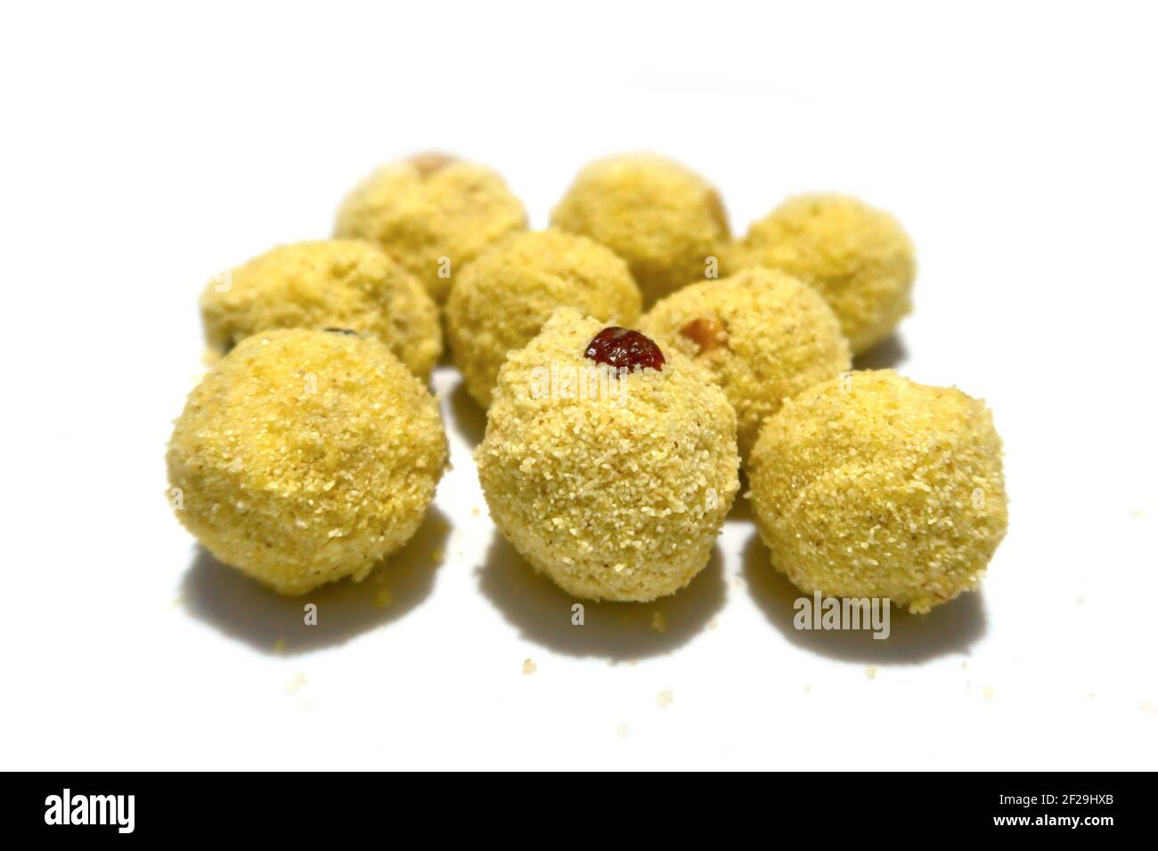 Kugelförmige indische Süßigkeit in gelber Farbe aus rava, Zucker, Rosinen und Cashewnuss. Stockfoto