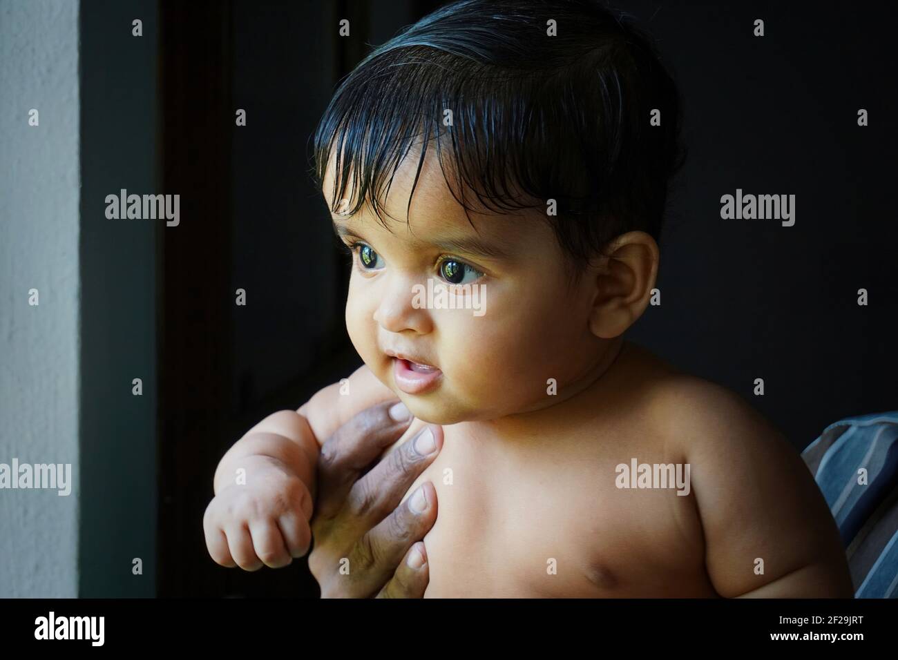 Ein Jahr altes indisches Mädchen in den Händen ihres Großvaters Stockfoto