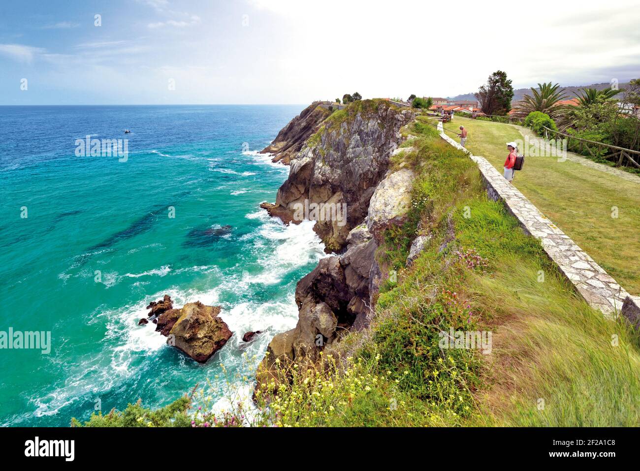 Frau mit Blick auf Klippen und Meer auf einem Küstenwanderweg Stockfoto