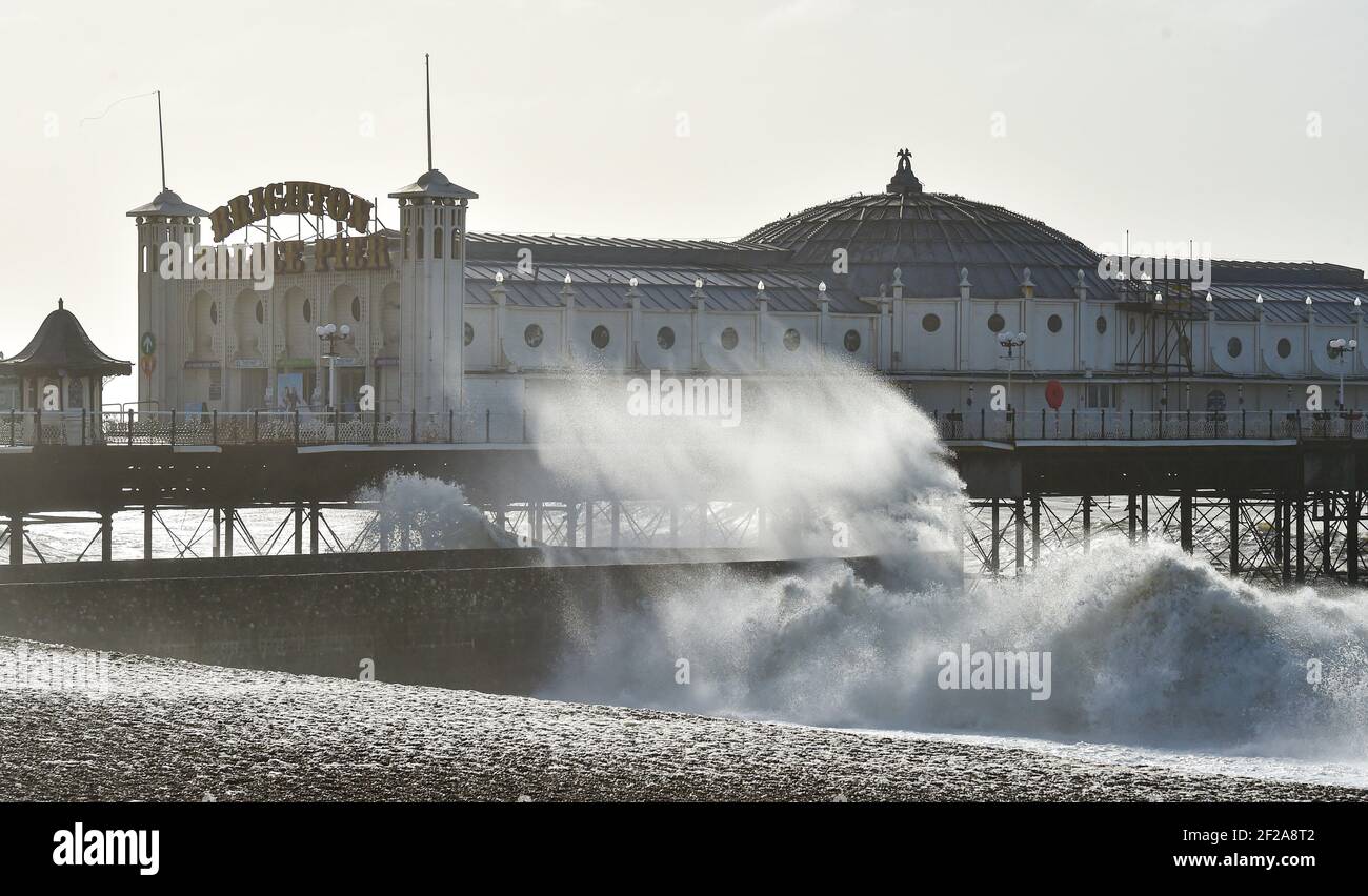 Brighton UK 11th March 2021 - Wellen stürzen heute am Brighton Palace Pier auf den Strand, als stürmisches Wetter die Südküste schlägt : Credit Simon Dack / Alamy Live News Stockfoto