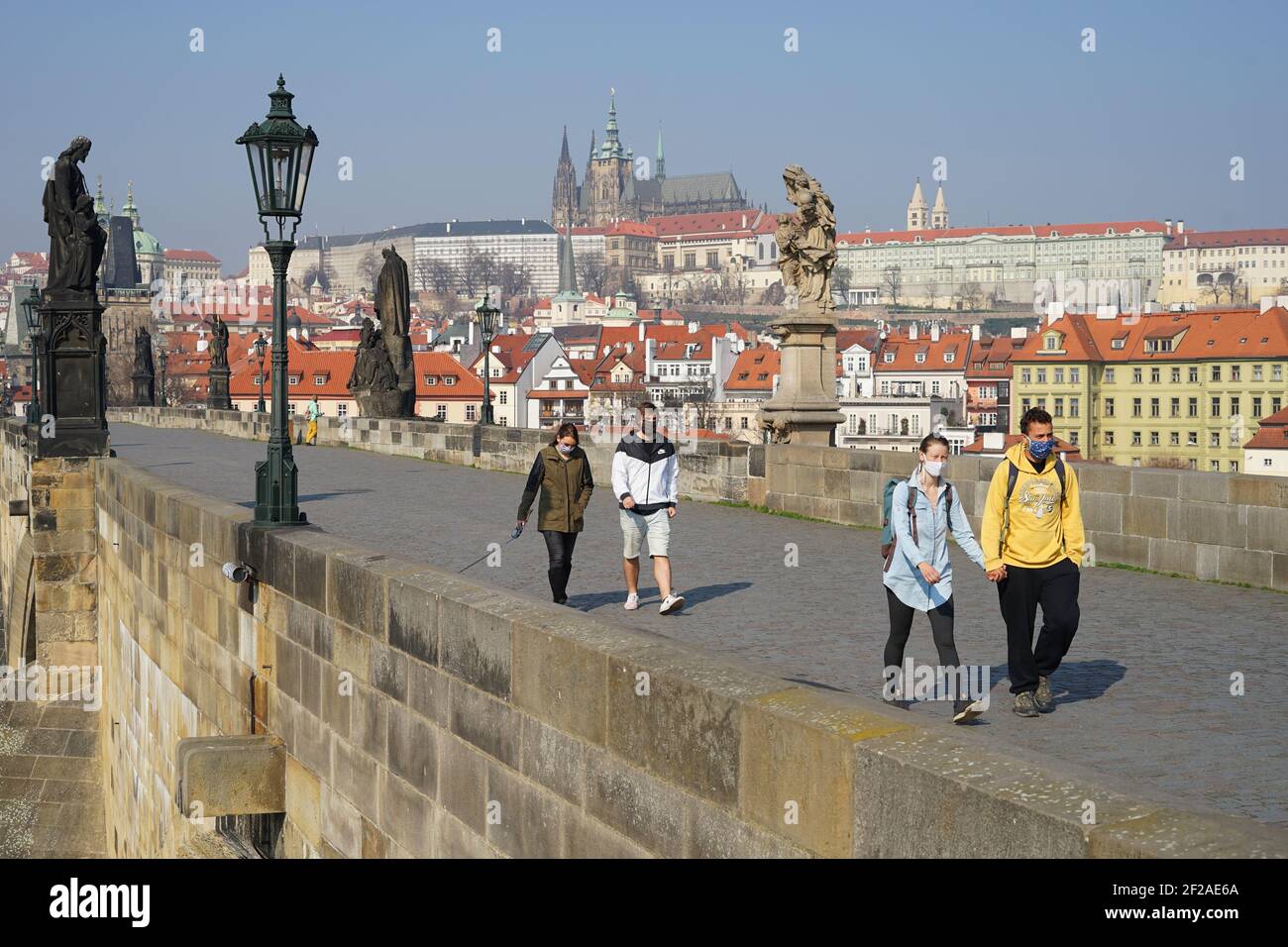 Prag, Tschechische Republik - März 20 2020: Gruppe von Jugendlichen mit Schutzmaske während des Coronavirus 2019-NCoV Ausbruchs auf der berühmten Karlsbrücke i Stockfoto