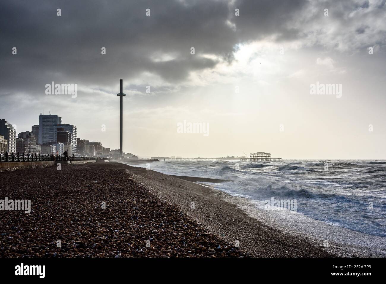 Brighton & Hove, Großbritannien. MÄRZ 11th 2021. Die Sonne bricht über Brighton's Piers und der BA i360 durch Wolken, während riesige Wellen und starke Winde die Küste von Brighton & Hove durchziehen. Foto ©Julia Claxton Credit: Julia Claxton/Alamy Live News Stockfoto