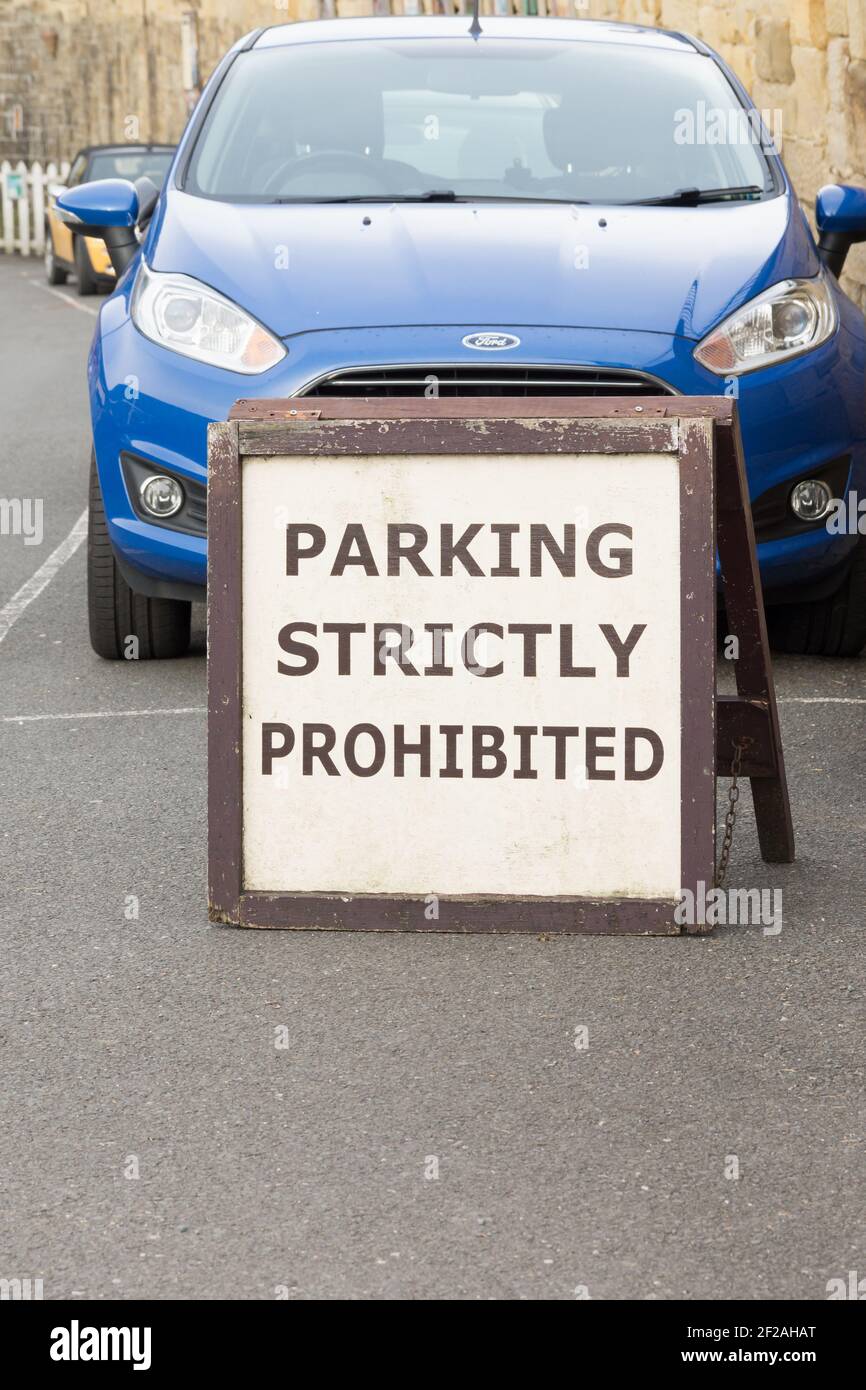 Seltsame Nebeneinanderstellung eines Parkverbotszeichens vor dem Hotel Eines geparkten Autos Stockfoto