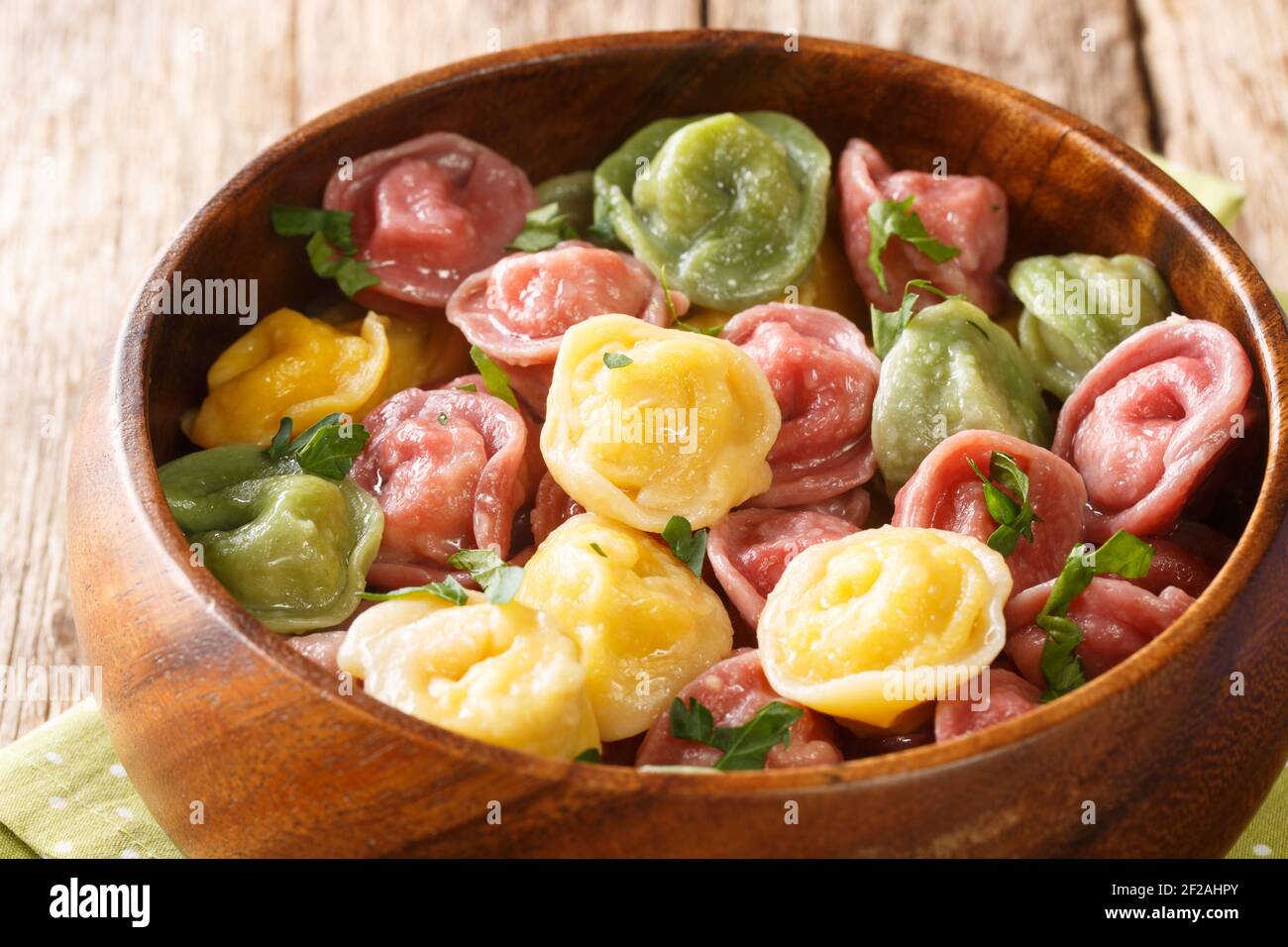 Gekochte mehrfarbige Tortellini Knödel close-up in einer Schüssel auf dem Tisch. Horizontal Stockfoto
