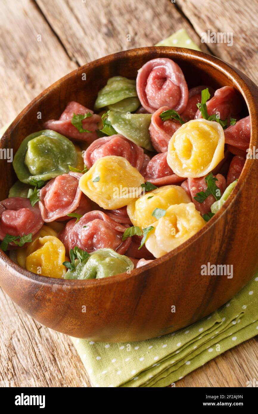 Natürliche Tortellini aus Spinat, Kürbis und Rote Bete Teig close-up in einer Schüssel auf dem Tisch. Vertikal Stockfoto