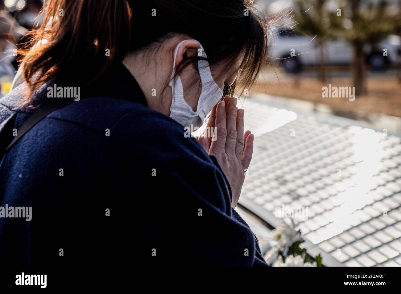 Ishinomaki, Japan. März 2021, 11th. Ein stilles Gebet wird während 14:46 der Zeit des Bebens im Jahr 2011 gesagt. Familien und Freunde kommen und suchen nach Namen und bieten Blumen und Kostenträger zum Gedenken an die Lieben im neuen Gedenkpark, der heute in Ishinomaki eröffnet wurde. Japan ist 10 Jahre her, seit ein massives Erdbeben, Tsunami und eine Atomkrise den Nordosten Japans hart getroffen haben. Kredit: SOPA Images Limited/Alamy Live Nachrichten Stockfoto