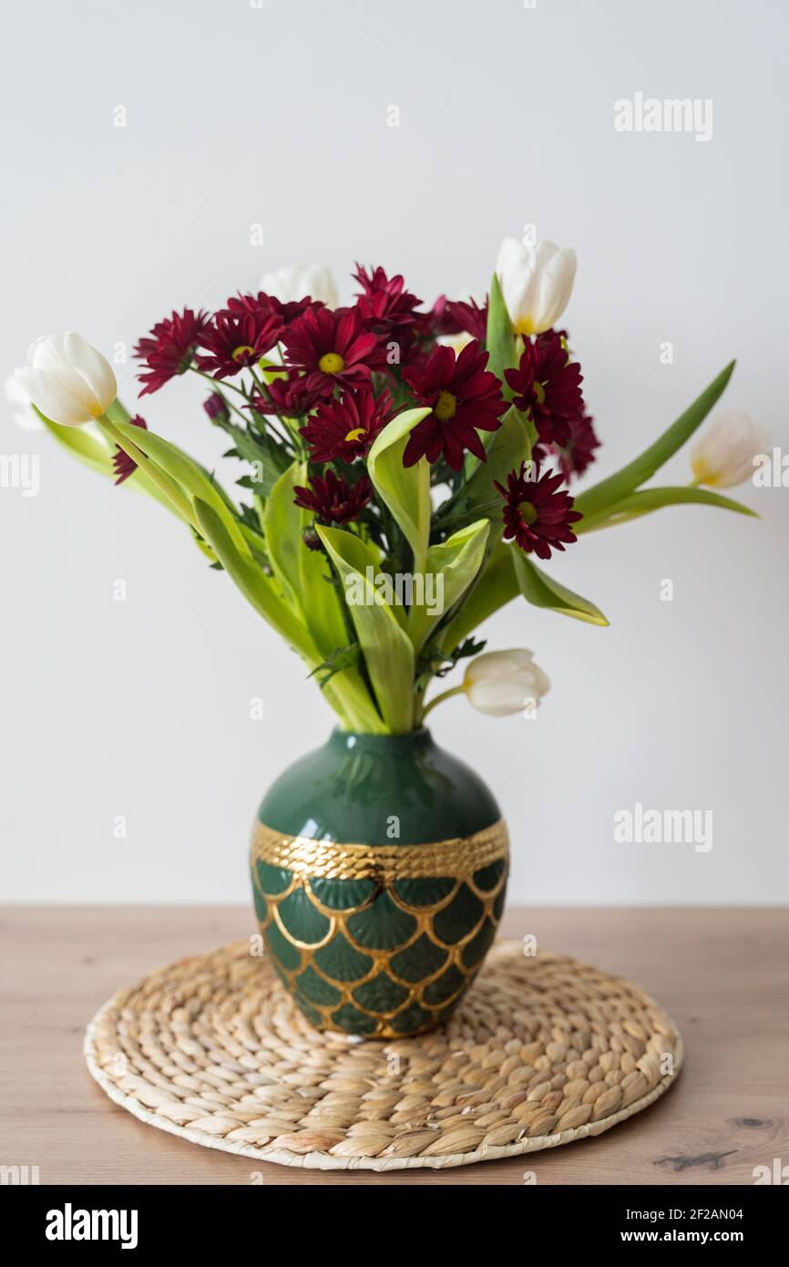 Bouquet von Tulpen und Chrysanthemen in einer Vase auf weißem Hintergrund. Stockfoto