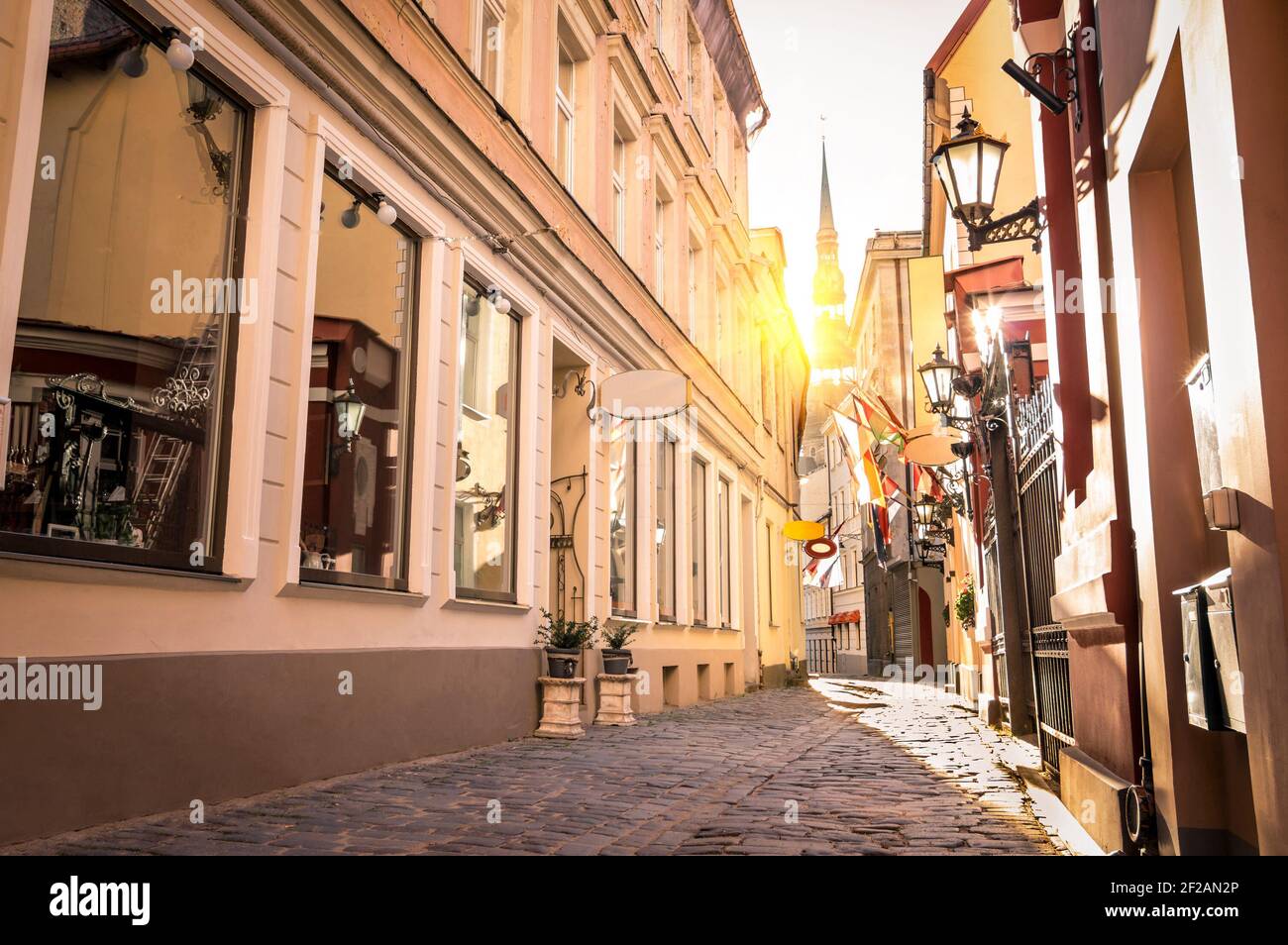 Vintage retro Reise Bild von einer engen mittelalterlichen Straße in Altstadt Riga bei Sonnenuntergang - Lettland Stockfoto