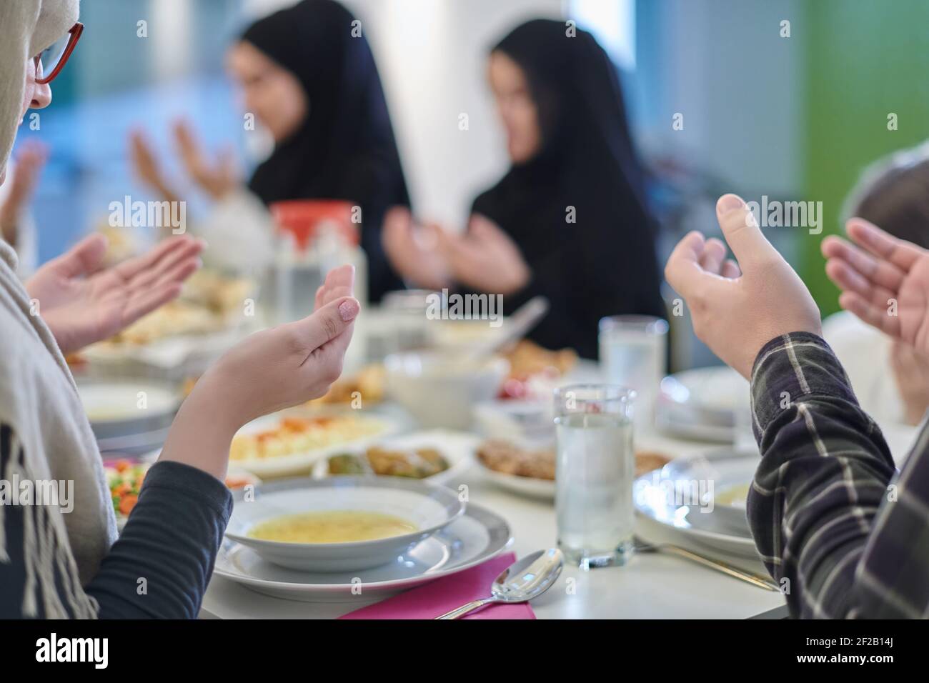 Muslimische Familie macht iftar dua Fasten während Ramadan zu brechen. Stockfoto