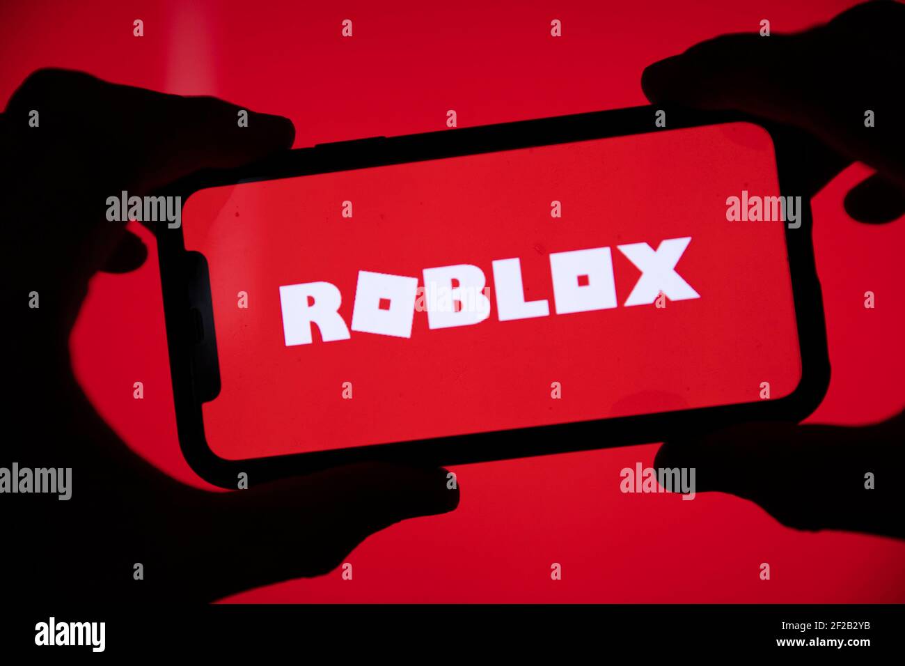 LONDON, UK - März 2021: Person mit einem Smartphone mit Roblox-Spiel-Logo Stockfoto