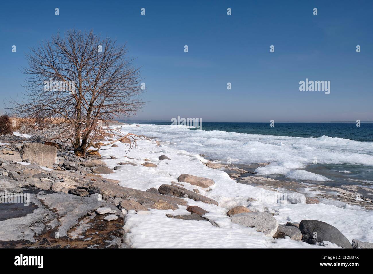 Eis häufen sich und der Schnee beginnt am Ufer der Amherst Island im Lake Ontario zu schmelzen, da der Winter zu Ende geht Stockfoto