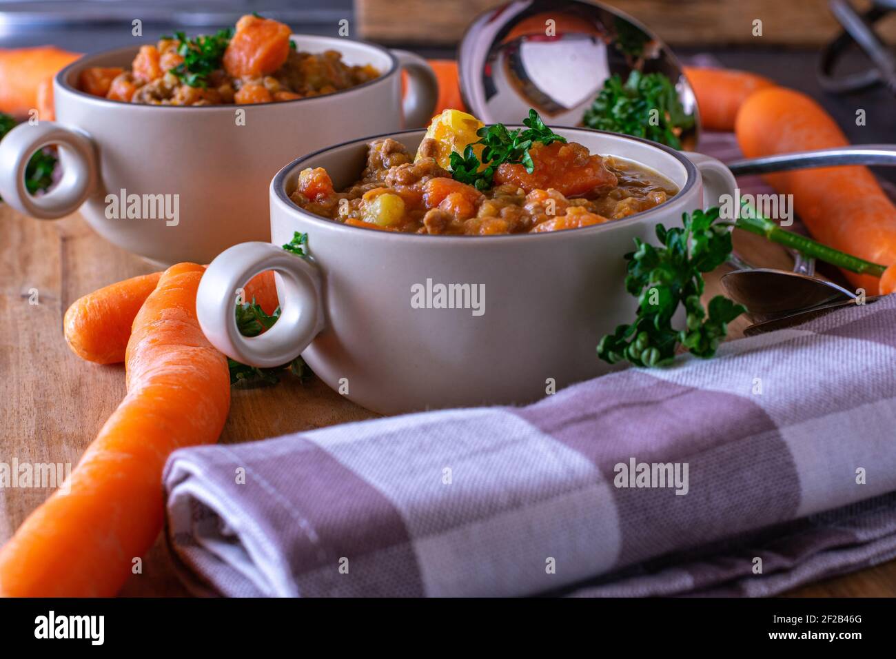 Leckeres Gemüse Hülsenfrüchte Suppe mit Hackfleisch in rustikaler Suppe Tassen auf Holztisch serviert Stockfoto