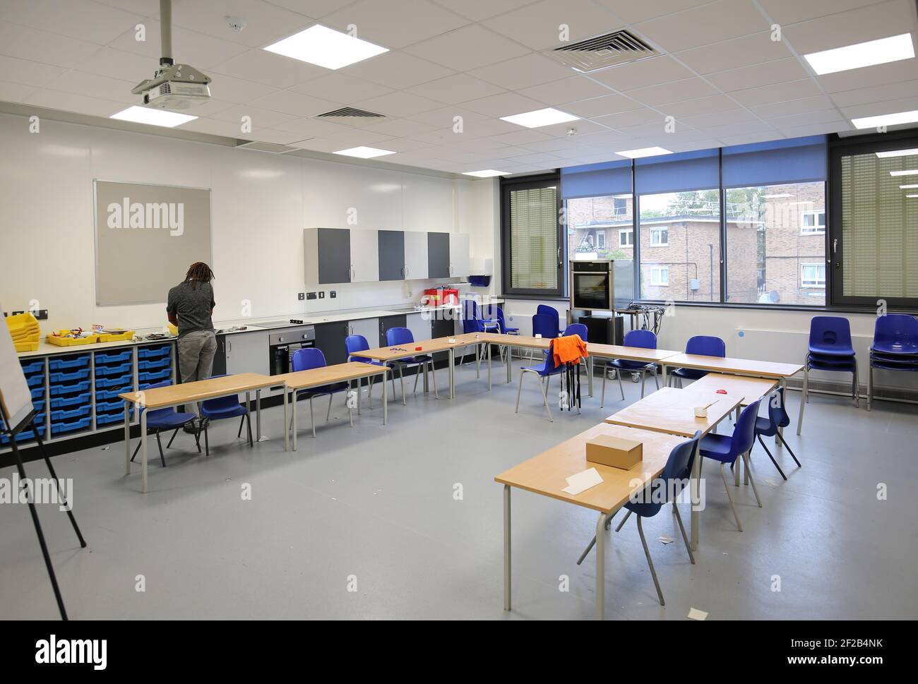Ein Kunstlehrer arbeitet allein in einem Klassenzimmer in einer neu aufgebauten Grundschule im Süden Londons, Großbritannien. Stockfoto