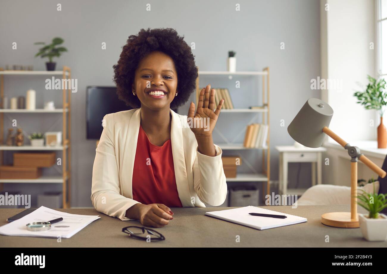 afroamerikanische Geschäftsfrau winkt vor der Webcam und begrüßt die Teilnehmer der Online-Konferenz. Stockfoto