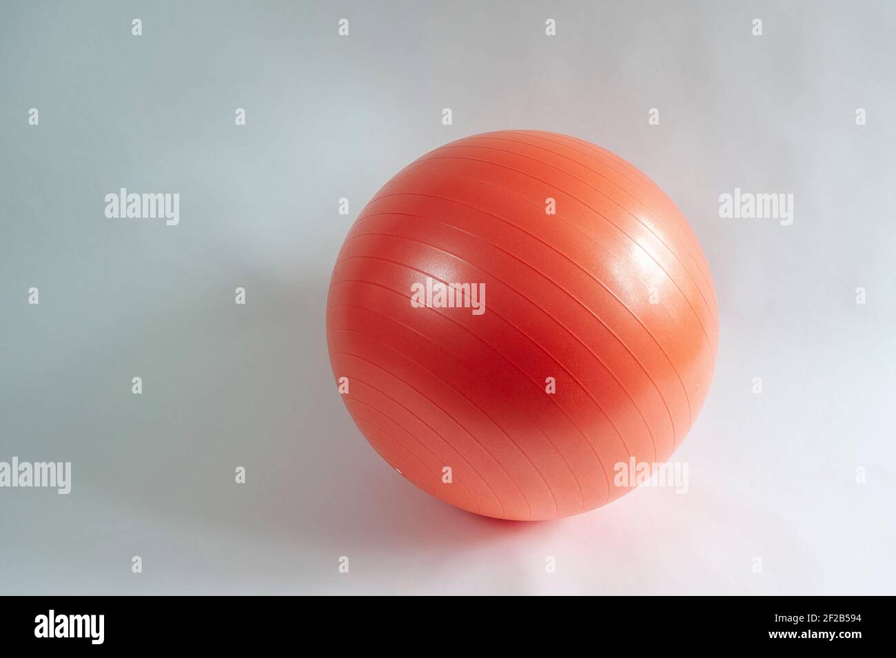 Aufnahme einer roten aufblasbaren Sportkugel mit mittlerer Brennweite vor weißem Hintergrund. Stockfoto