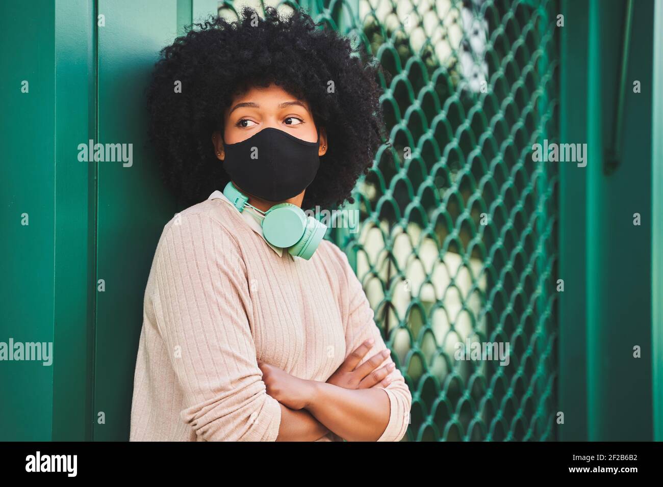 Latina Frau mit afro Haar trägt Schutzmaske. Porträt einer afroamerikanischen Frau. Hochwertige Fotos Stockfoto