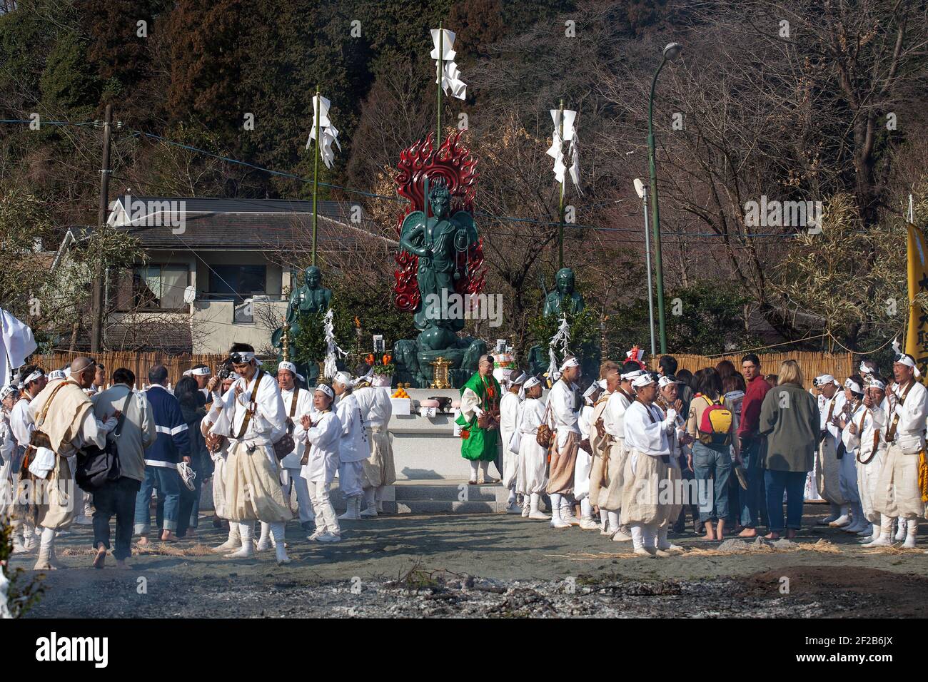 Statue von Izuna Daigongen beobachtet japanische Freiwillige beim Hiwatari Matsuri - Fire Walking Festival, Mount Takao, Hachioji, Japan, über brennende Kohle laufen Stockfoto