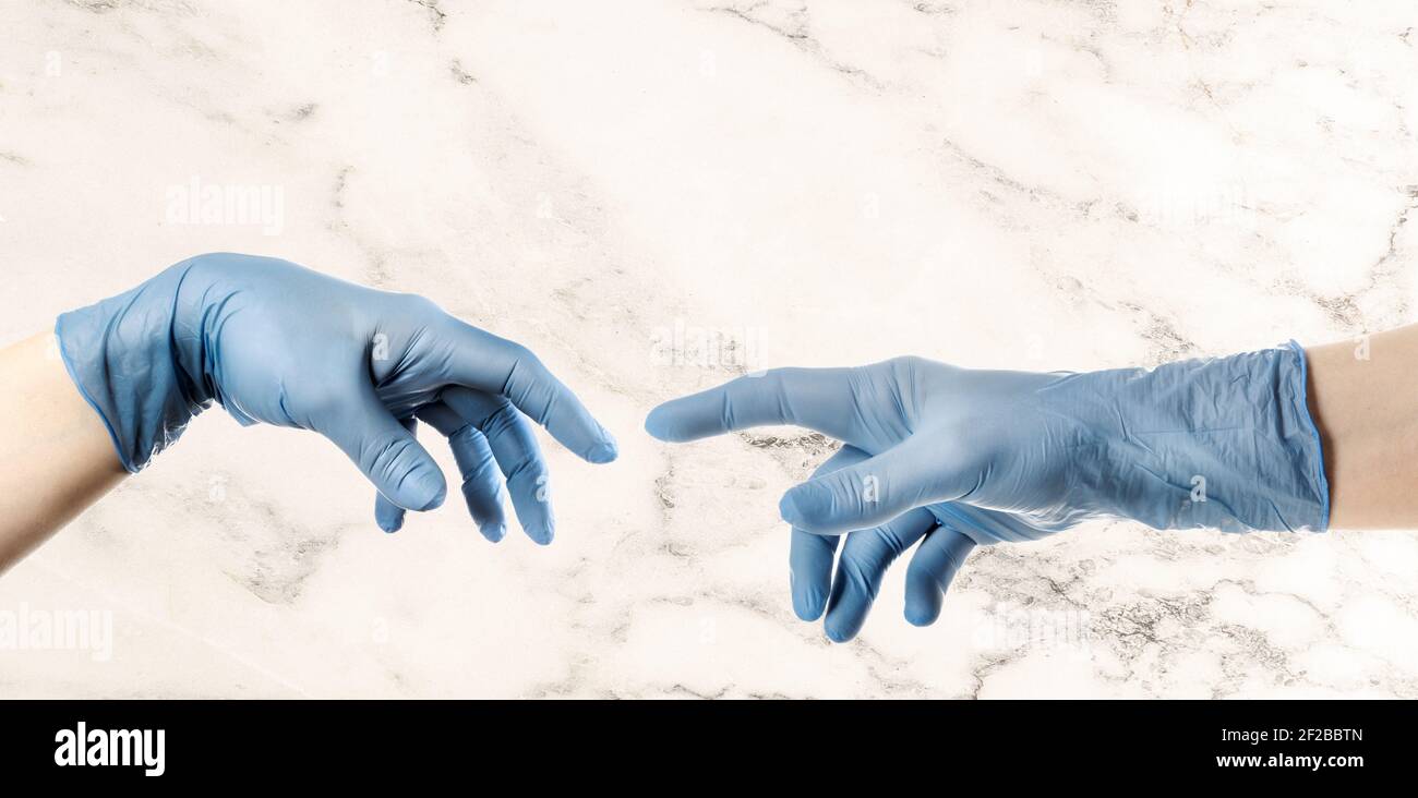 Hände mit blauem Handschuh nach Michelangelos Gemälde von Gott erschafft den Menschen die Schöpfung Adams Stockfoto