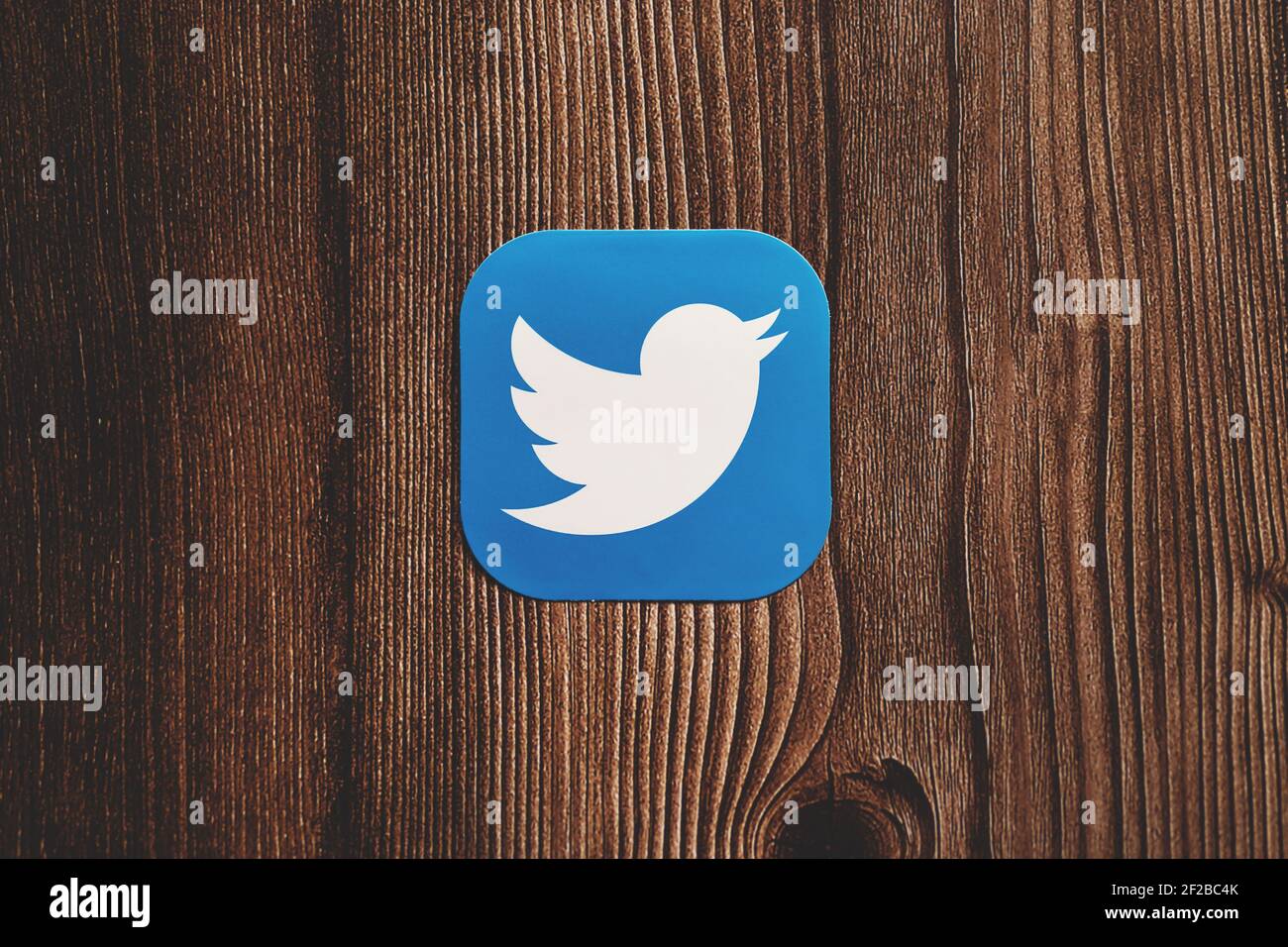 Twitter App blaues Logo mit Vogel auf Papier gedruckt zentral Platziert auf Holzhintergrund Stockfoto