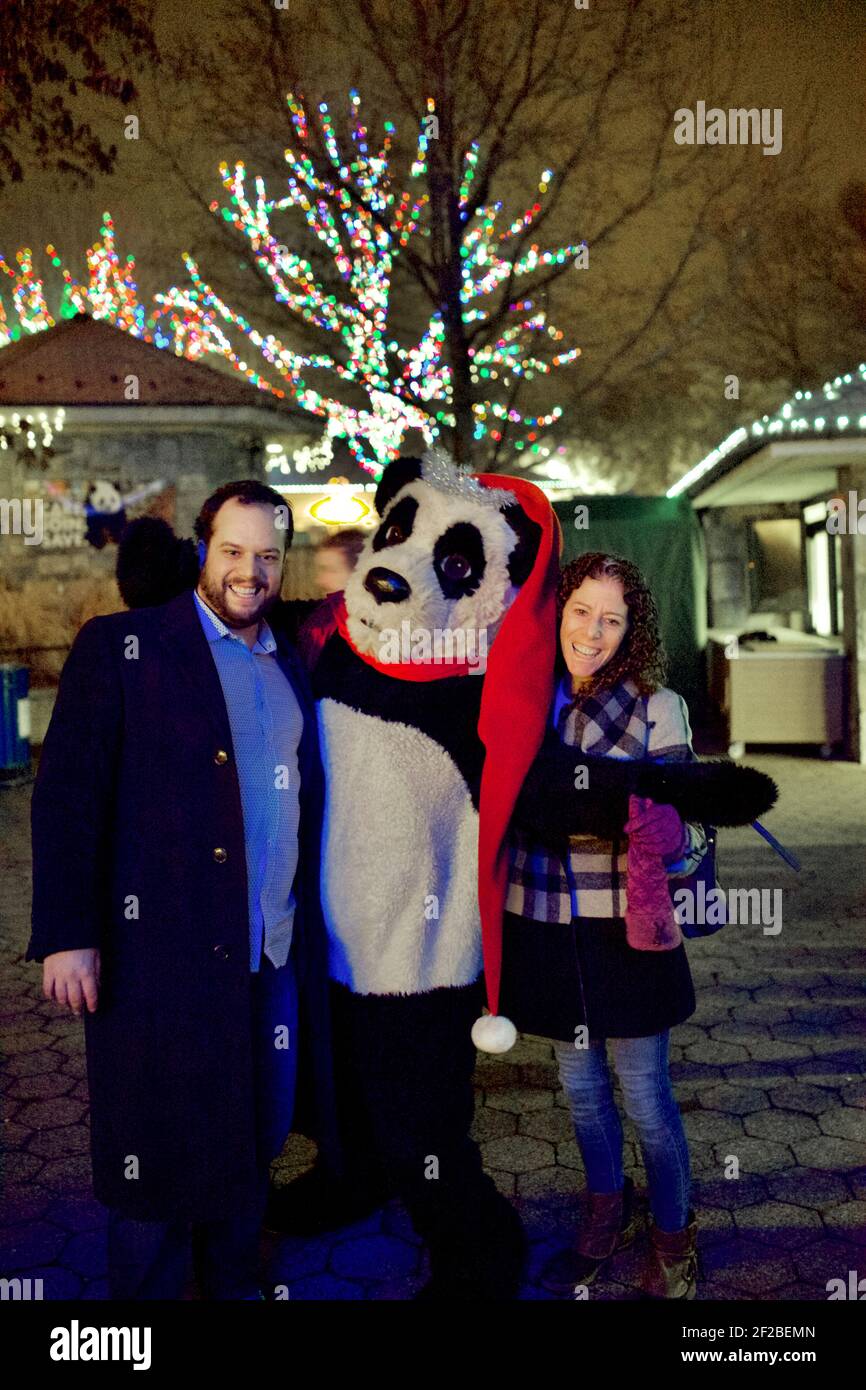 Menschen mit Maskottchen bei der Zoo Lights Night im Smithsonian National Zoological Park im Dezember jedes Jahres, um die Saison zu feiern. Stockfoto