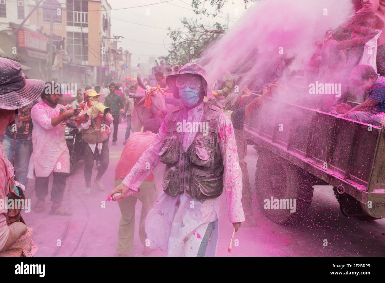 Indien, Mathura - Teilnehmer Anziehen Maske und Brillen taucht aus dem  farbigen Pulver geworfen in der Holi Prozession in Mathura Stockfotografie  - Alamy