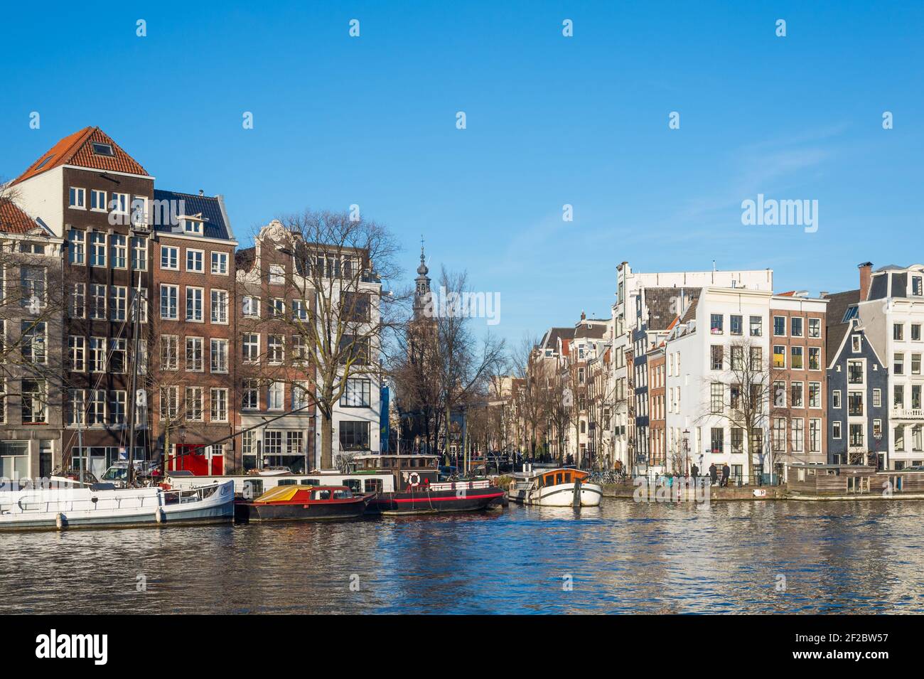 Gebäude auf der Amstel zu beiden Seiten von Groenburgwal auf 's-Gravelandseveer und Staalkade, Amsterdam, Niederlande. Stockfoto