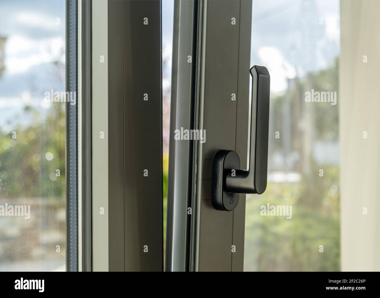 Metall- oder PVC-Fenster vertikal öffnen Nahaufnahme. Kippen und drehen graue Farbe Aluminium-Fenster, frische Luft für zu Hause. Energieeffizientes Sicherheitsprofil aus Metall Stockfoto
