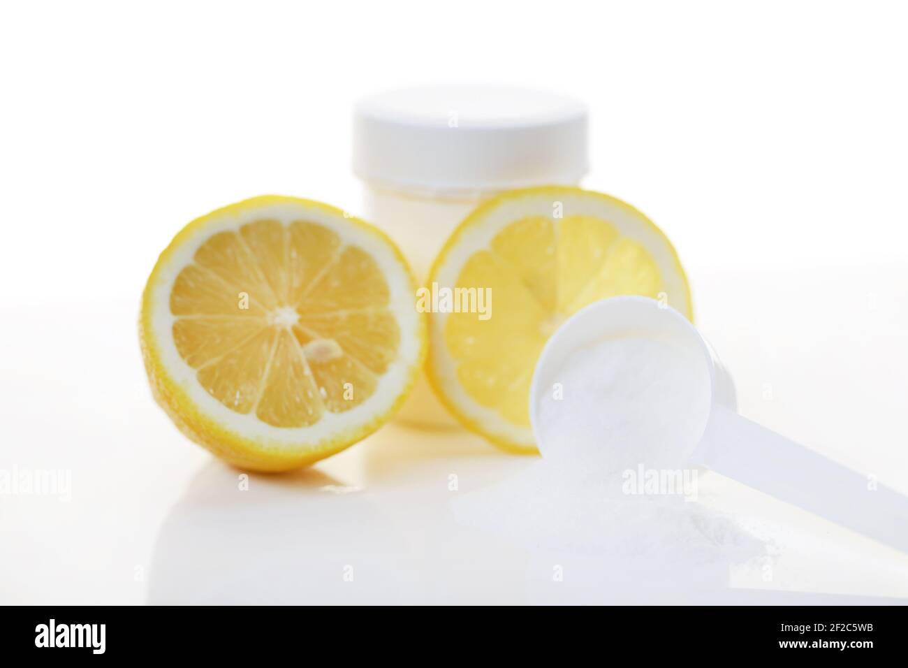Vitamin C Pulver .Weisses Glas und Messlöffel, Vitamin C weißes Pulver und Zitronen in einem Schnitt.Prävention von Erkältungen und Grippe. Ein Medikament zur Stärkung Stockfoto
