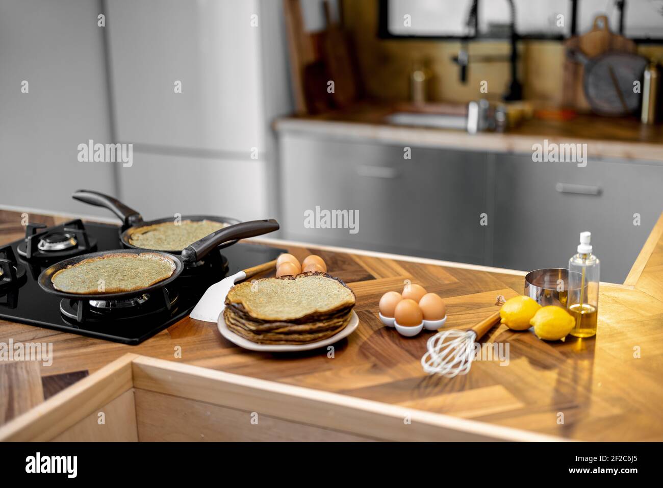 Zubereitung von Pfannkuchen zum Frühstück, Zutaten und gebratene Pfannkuchen auf dem Holztisch in der Küche zu Hause Stockfoto