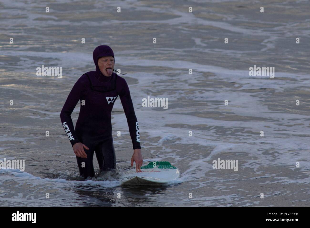 Ein Surfer am Coney Beach, Porthcawl bei Flut und starken Winden von 67mph trifft die South Wales Coast am 11th. März 2021. Kredit: Lewis Mitc Stockfoto