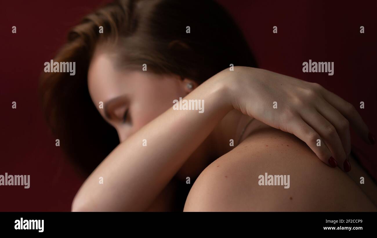 Einsame, traurige junge Frau, die weint und sich hinter ihrer Hand versteckt. Stockfoto