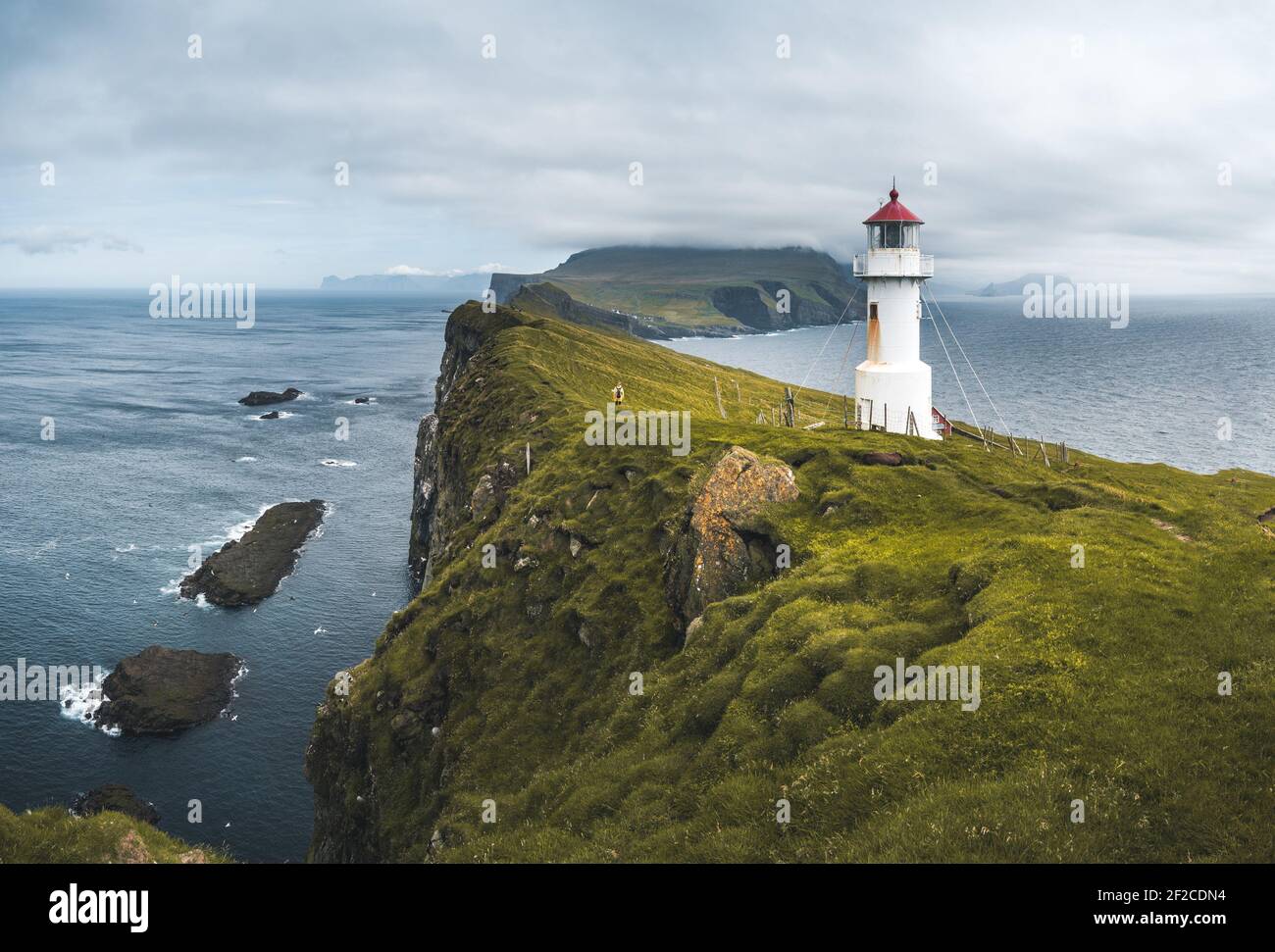 Blick zum Leuchtturm auf der Insel Mykines Holmur, Färöer Insel ein bewölktes Tag mit Blick auf den Atlantik. Stockfoto