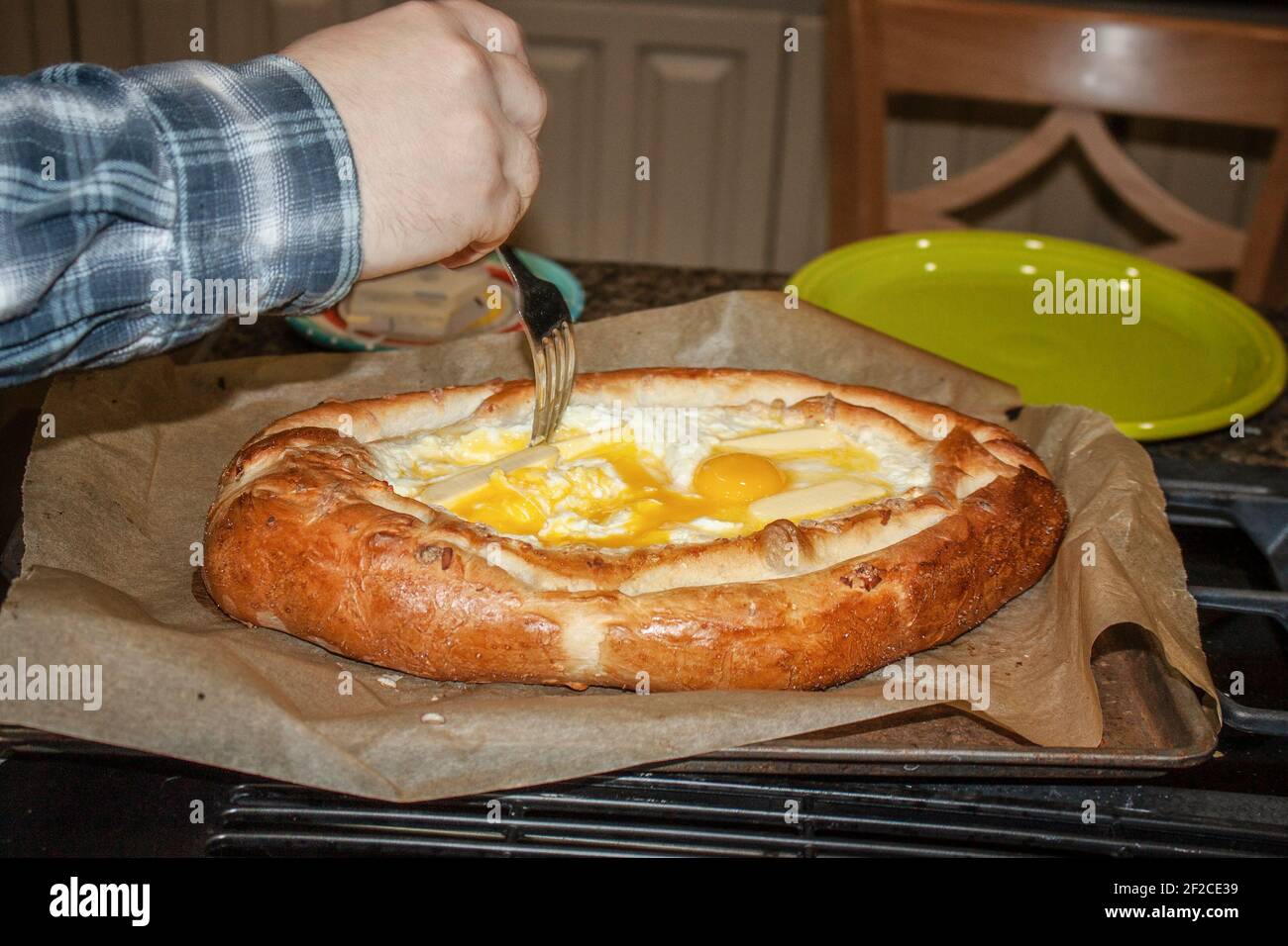 Georgische khachapuri - frisch aus dem Ofen mit Butter schmelzen In heißem Käse und Handrühren in der Butter und Rohes Ei Stockfoto