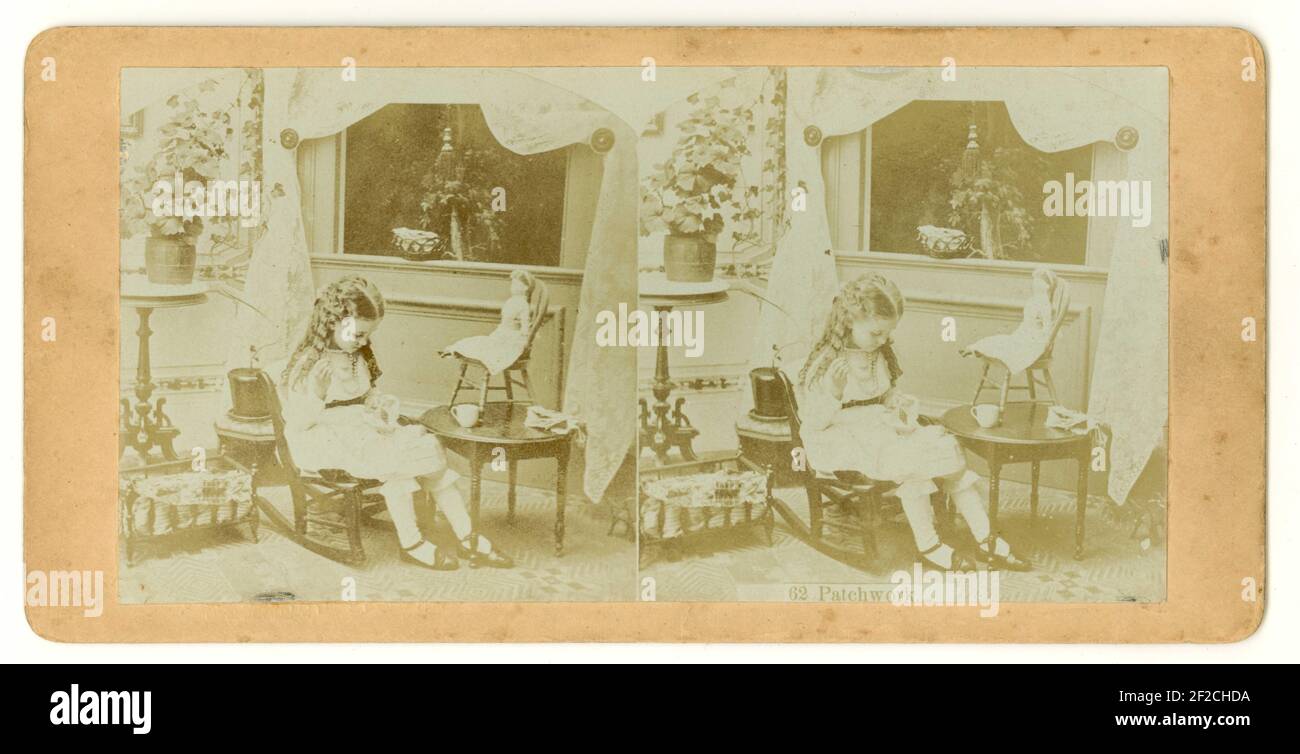 Original viktorianisches stereographisches Bild eines jungen Mädchens, das mit einer Puppe in ihrem Schlafzimmer sitzt und näht - mit der Aufschrift „Patchwork“, ca. 1860 in den Vereinigten Staaten von Amerika Stockfoto