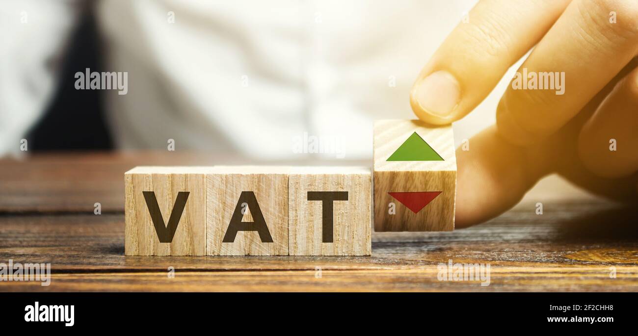 Holzklötze mit den Worten VAT und auf- und Abwärtspfeilen. Mehrwertsteuerkonzept. Steuer auf den Staatshaushalt von einem Teil der Kosten für Waren. Business und Stockfoto