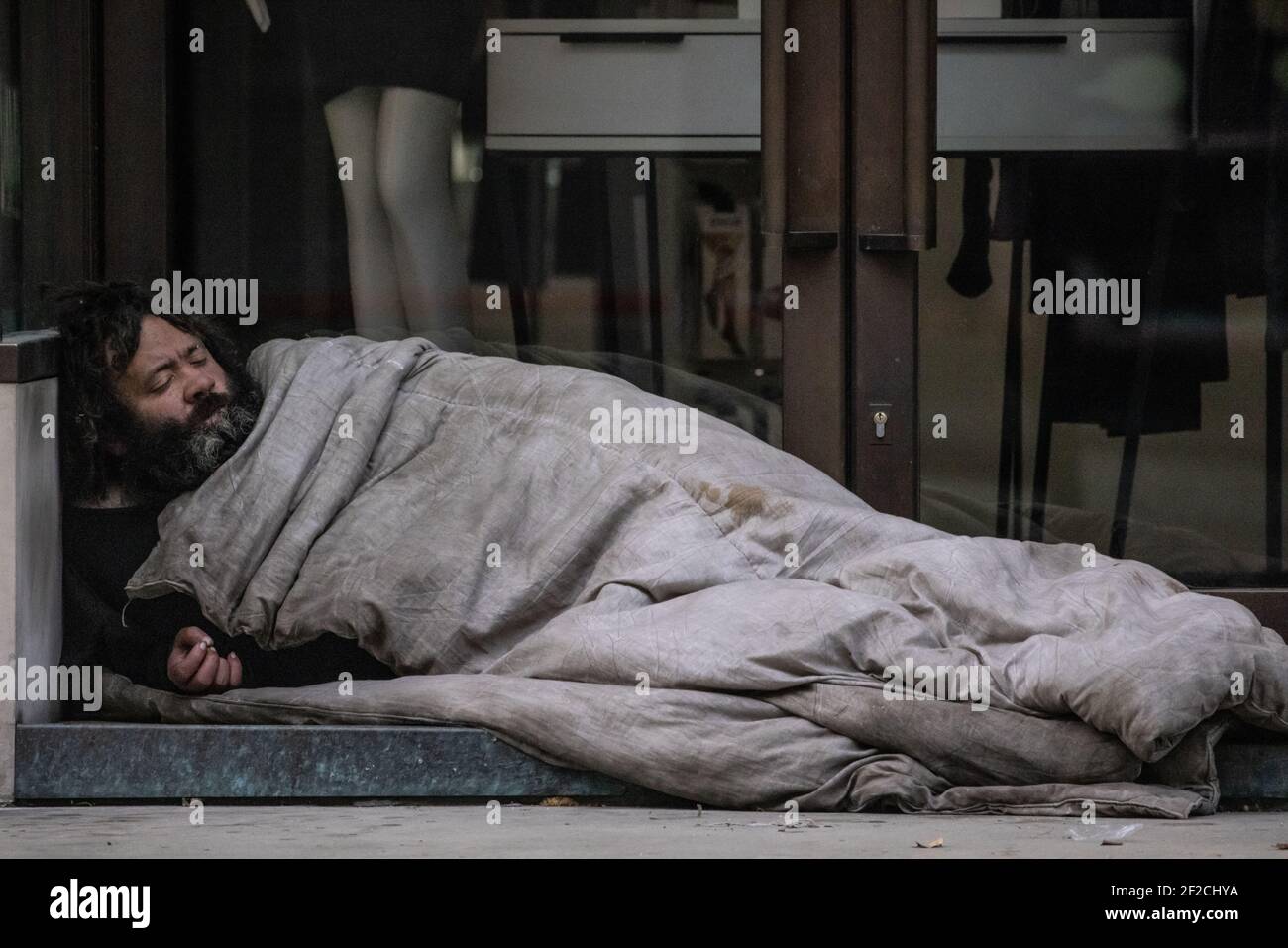 Obdachloser, der in einem Ladeneingang entlang der Regent Street, Central London, England, Großbritannien schläft Stockfoto