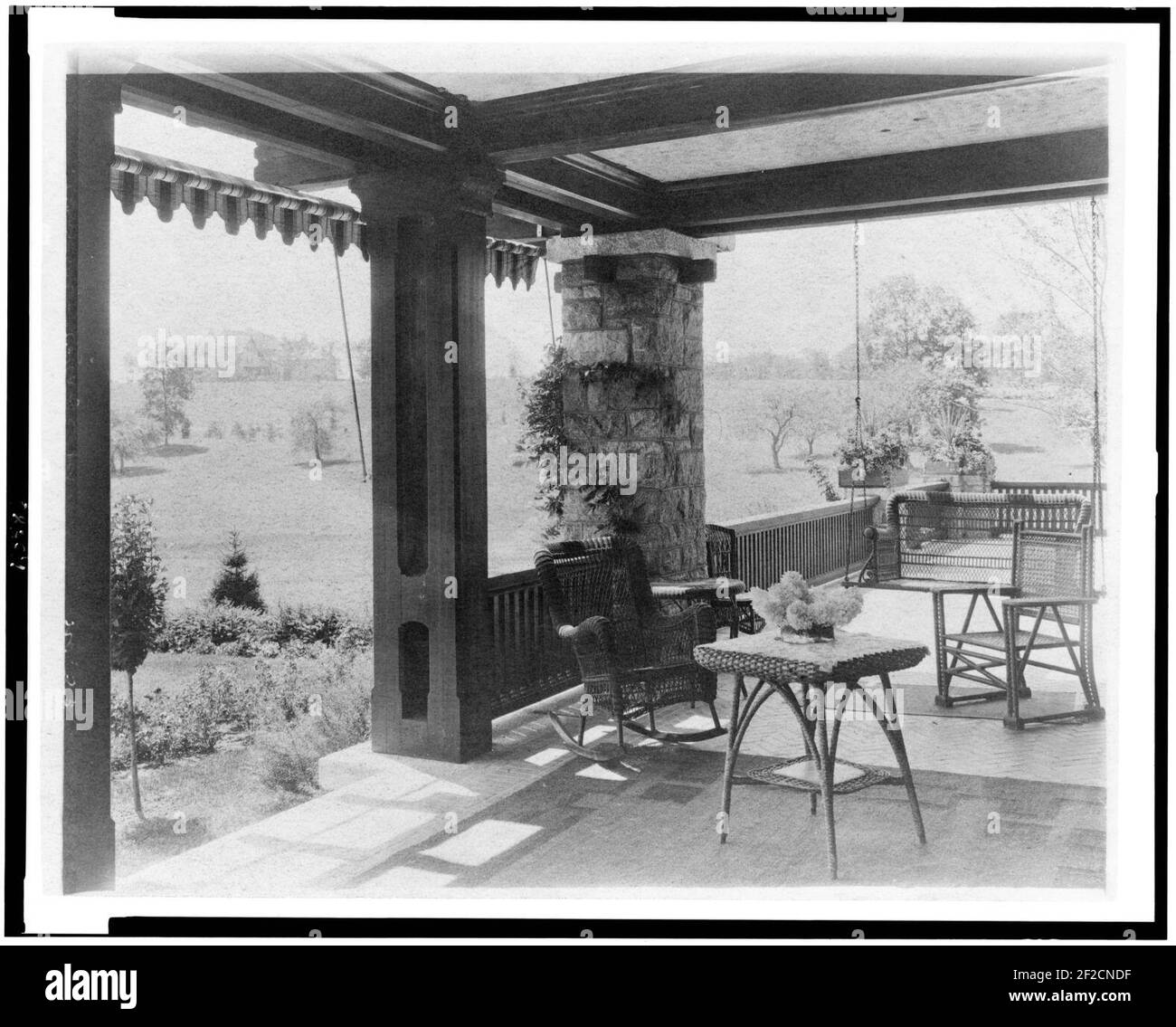 Terrasse mit Korbmöbeln und Blick auf Rasen zur Startseite von Edmund Cogswell Converse, Greenwich, Connecticut Stockfoto